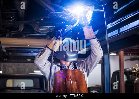 Mechaniker schweißen Auto in Werkstatt Stockfoto