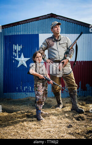 Familie, die auf dem Feld mit Gewehr gegen Texas flag Stockfoto