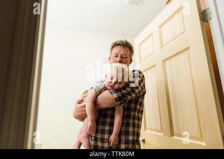 Low Angle View der Vater die schlafenden Sohn beim Stehen an der Tür im Haus Stockfoto