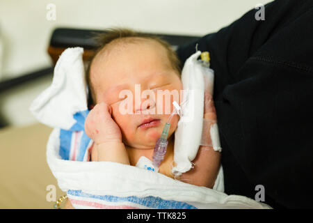Neugeborenes Mädchen in der Decke mit IV in ihrer Hand gewickelt Stockfoto