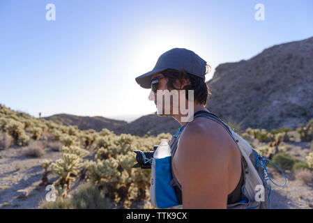 Wanderer Wandern mit DSLR-Kamera und Rucksack in der Wüste Berge Stockfoto