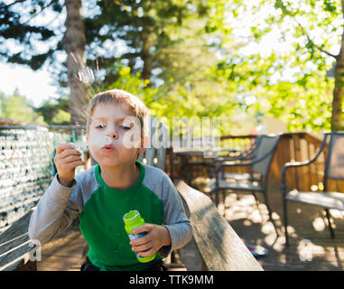 Junge bläst Seifenblasen im Hof Stockfoto