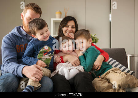 Glückliche Familie sitzt zu Hause auf sofa Stockfoto