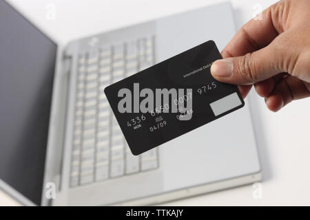 Personen-Hand mit einer Kreditkarte über einen laptop Stockfoto