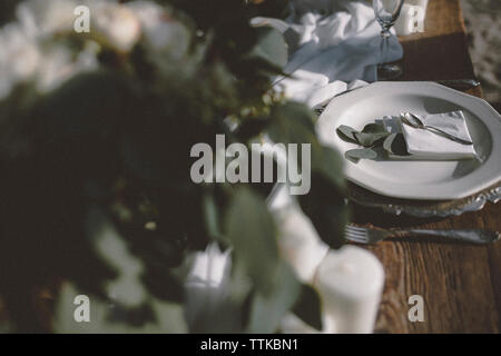Hohe Betrachtungswinkel der Platte mit Besteck am Tisch am Strand arrangiert während der Trauung Stockfoto