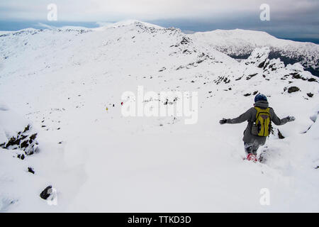Ansicht der Rückseite des Wanderer Laufen auf Schnee bedeckten Berg gegen Sky Stockfoto