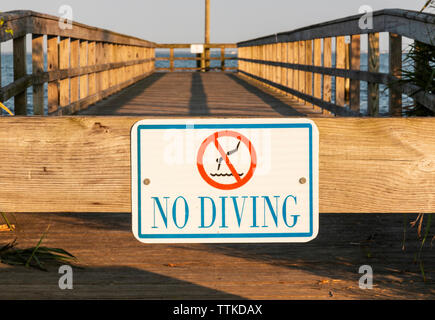Ein No Diving ist auf einem hölzernen Pier an der Küste von Long Island, New York, genagelt. Stockfoto