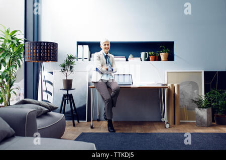 Zuversichtlich smiling Architect bei Tisch sitzen im Büro Stockfoto