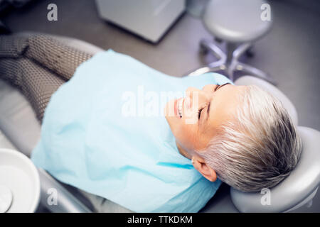 Hohe Betrachtungswinkel und der lächelnde Frau sitzen auf dem Zahnarztstuhl Stockfoto