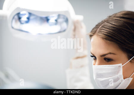 In der Nähe der weiblichen Zahnarzt Einstellung leuchtet die Lampe in Klinik Stockfoto