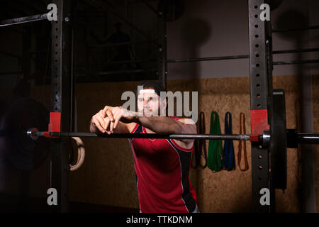 Sportsman lehnte sich auf Barbells in der Turnhalle Stockfoto