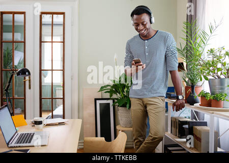 Glückliche Menschen mit smart phone zu Hause Büro Stockfoto