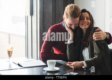 Happy business Paar umarmen im Cafe Stockfoto