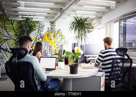 Geschäftsleute, die Computer am Schreibtisch in kreativen Büros nutzen Stockfoto Geschäftsleute, die Computer am Schreibtisch in kreativen Büros nutzen Stockfoto
