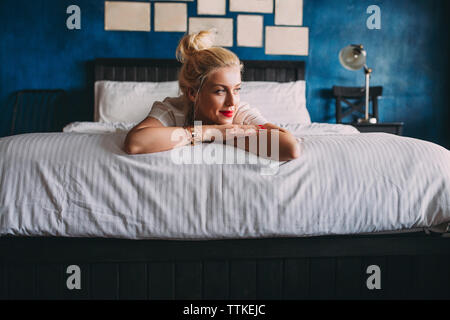 Frau weg, während am Bett zu Hause liegen Stockfoto
