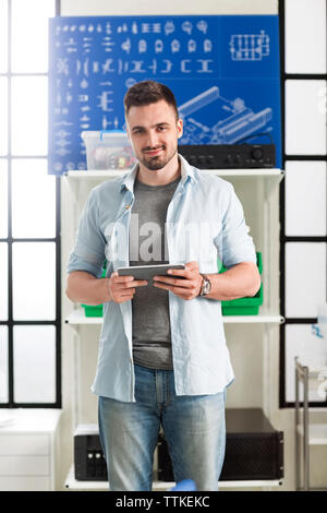 Portrait von zuversichtlich Ingenieur Holding digital Tablet in elektronischen Labor Stockfoto