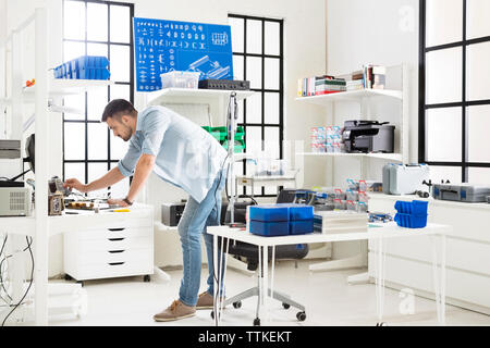 Seitenansicht der Ingenieur bei der Tabelle in elektronischen Labor Stockfoto