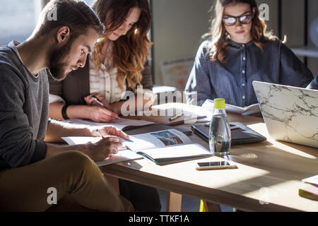 Studenten studieren an Tabelle im Klassenzimmer Stockfoto