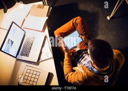 Hohe Betrachtungswinkel des Menschen lesen durch Tablet-PC in der Bibliothek Stockfoto