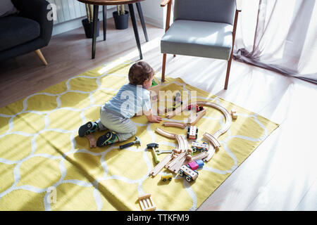 Hohe Betrachtungswinkel von baby Junge spielt mit Spielzeugeisenbahn zu Hause Stockfoto