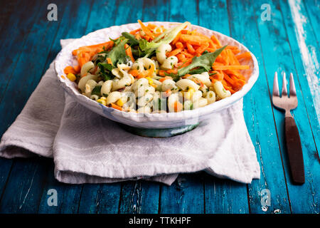Hohe Betrachtungswinkel von Pasta und Salat serviert in der Schüssel auf dem Tisch Stockfoto