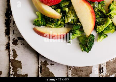 Ansicht von oben von Brokkoli und Äpfel in der Platte auf dem Tisch Stockfoto