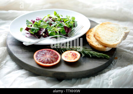 Hohe Betrachtungswinkel und der Salat mit Blutorange und Rosmarin von Brot auf Schneidebrett Stockfoto