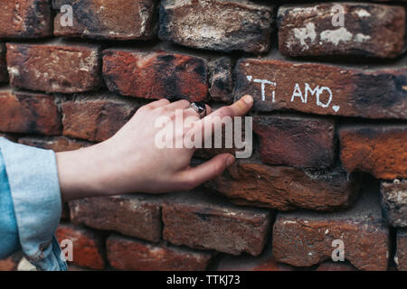 7/8 Hand der Frau, Text auf Wand Stockfoto