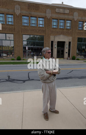 Ein Mann steht auf der anderen Straßenseite vom Auburn Cord Duesenberg Museum (ehemals die Auburn Automobile Company) in Auburn, Indiana, USA. Stockfoto