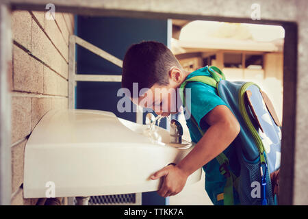 Close-up boy Trinkwasser aus Brunnen Stockfoto