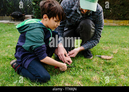 Vater, Sohn beim Schneiden von Gras in Newbury Park Stockfoto