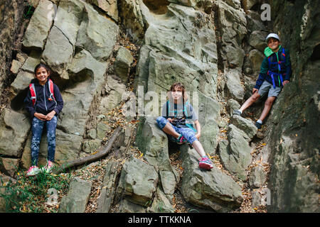 Low Angle Portrait von Happy Geschwister Klettern am Felsen Stockfoto