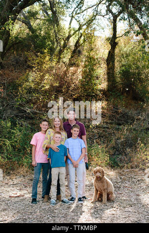 Familie von fünf Lächeln für ein Portrait mit pet Labradoodle Stockfoto
