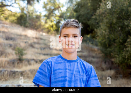 Lächelnd Portrait eines Jungen mit Klammern in der Natur Stockfoto