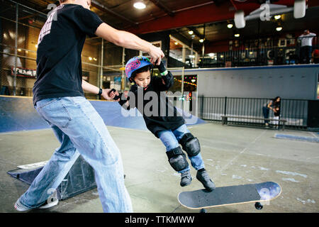 Skater Boy verliert sein Skateboard unter seine Füße nach einem Sprung Stockfoto