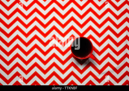 Ansicht von oben schwarzen Kaffee serviert in Schale auf Chevron gemusterten Tabelle Stockfoto