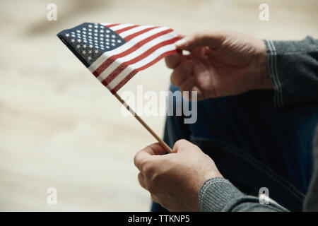 Mittelteil der Mann hält kleine amerikanische Flagge Stockfoto