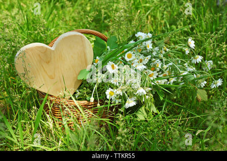 Holz- Herz in den Korb mit Blumenstrauß aus Daisy Flowers Stockfoto