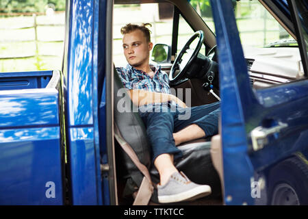 Der Mensch auf der Suche beim Liegen in der Pick-up-Truck Stockfoto