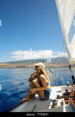 Mitte der erwachsenen Frau sitzt auf der Yacht Deck Stockfoto