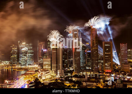 Feuerwerk über Wolkenkratzer an beleuchteten Stadtbild explodierende Stockfoto