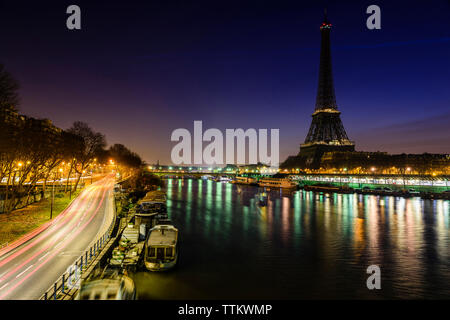 Leichte Wanderwege auf der Brücke über den Fluss von Eiffelturm bei Nacht Stockfoto