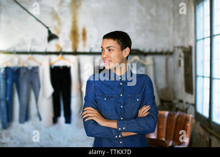Young Fashion Designer stehen mit der Waffe in der Werkstatt gekreuzt Stockfoto