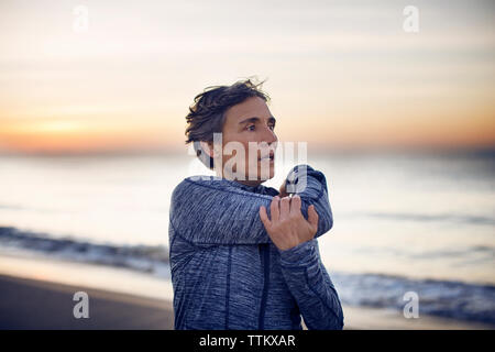 Frau trainieren am Strand gegen Sky Stockfoto