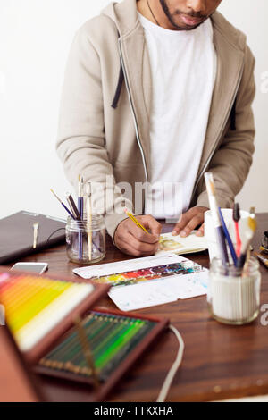 Männliche Illustrator die Malerei am Schreibtisch in der kreativen Büro Stockfoto