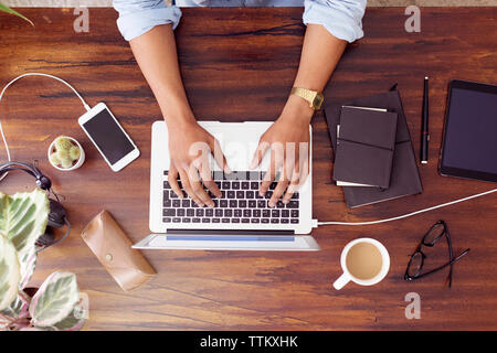 Direkt über der Geschäftsmann mit Laptop auf dem Schreibtisch in der kreativen Büro Stockfoto