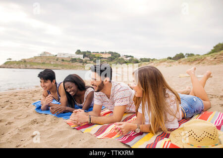 Glücklich, multi-ethnischen Freunde Erholung am Ufer am Strand Stockfoto