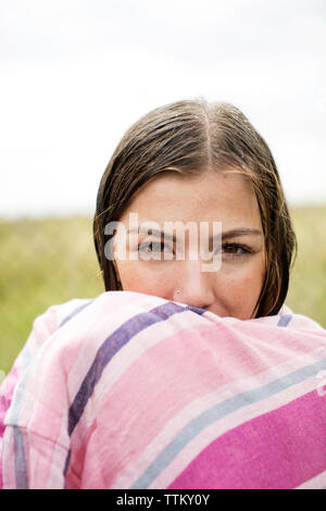 Portrait von nassen Frau in ein Handtuch eingewickelt im Hof Stockfoto