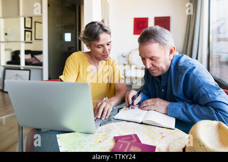 Reife Frau Planung Urlaub mit Mann zu Hause Stockfoto