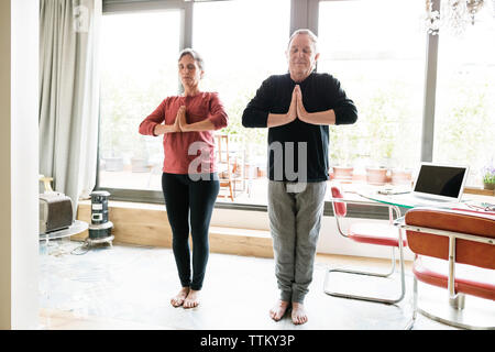Entspannt senior Paar Üben Yoga zu Hause Stockfoto